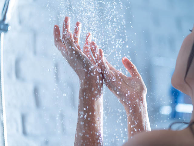 Female hands under shower water